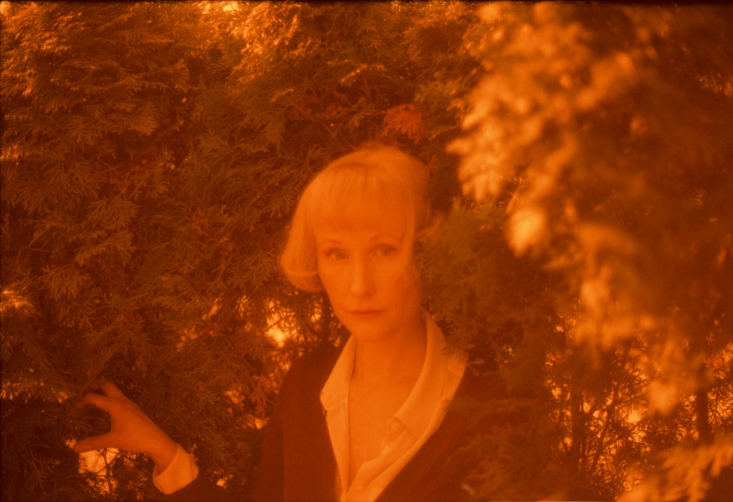 Kirjailija Iida Rauma puun lehtien katveessa