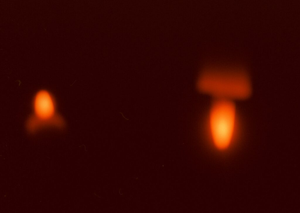 Kuva punaisesta liekistä punertavassa pimeässä