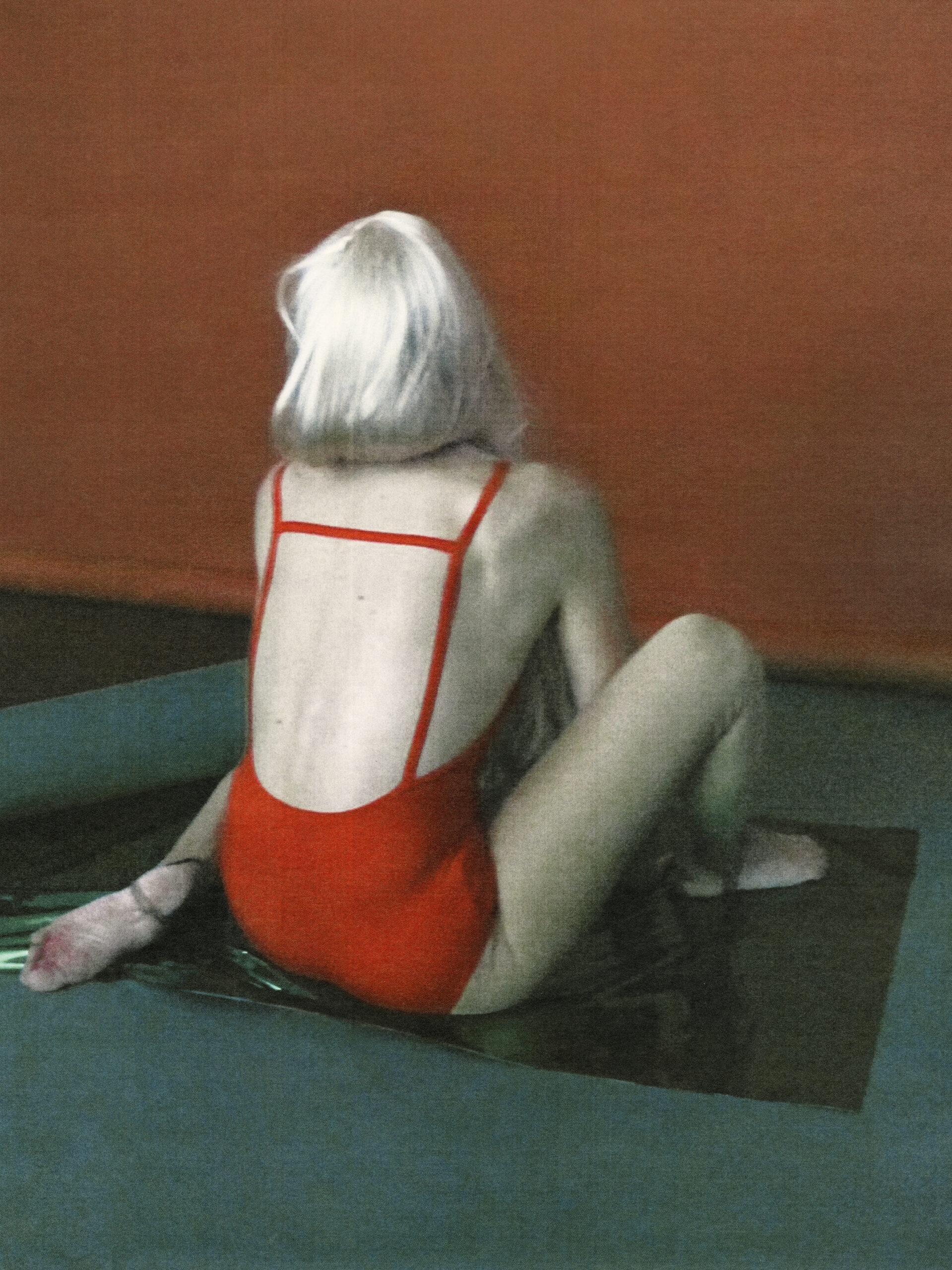 punaiseen uimapukuun pukeutunut naishahmo takaa päin nähtynä