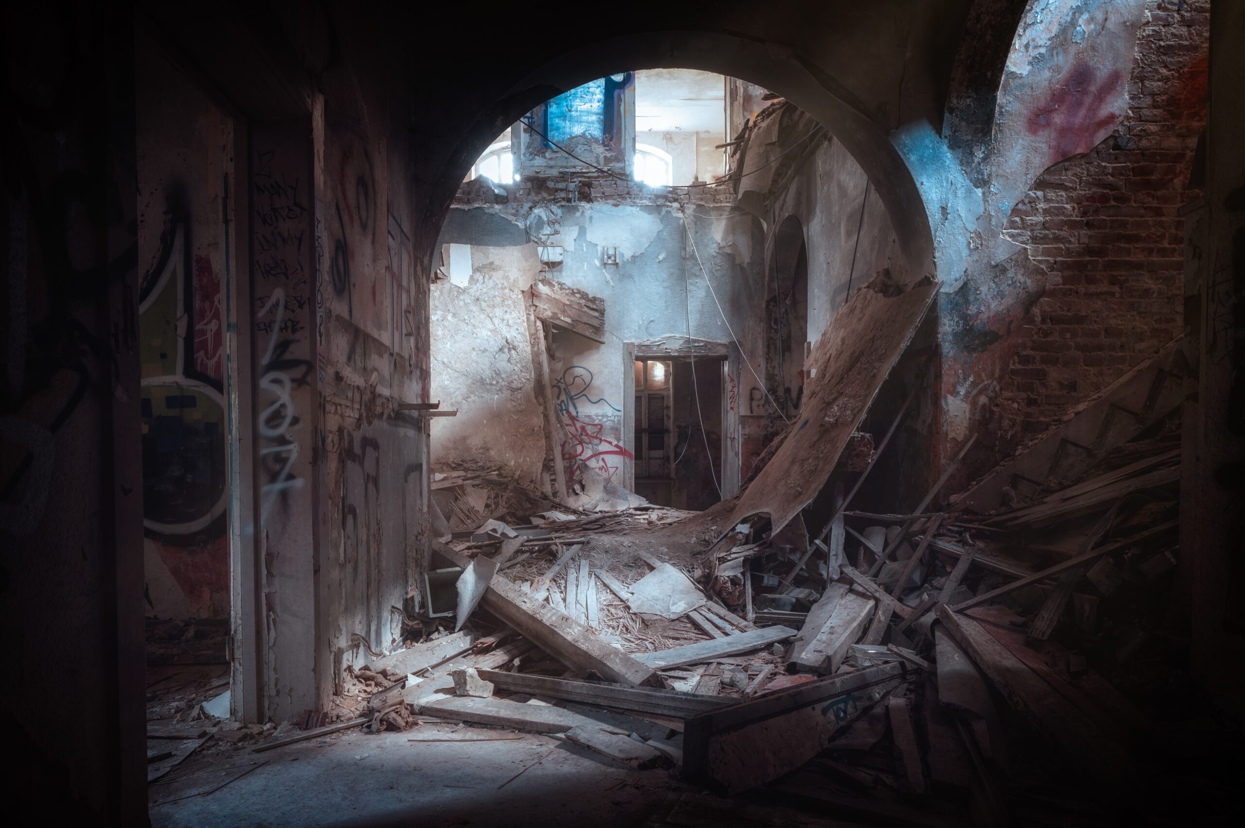 Kuva rakennuksen sisältä. Holvikaari on osittain sortunut. Holvikaarien alla on rojua